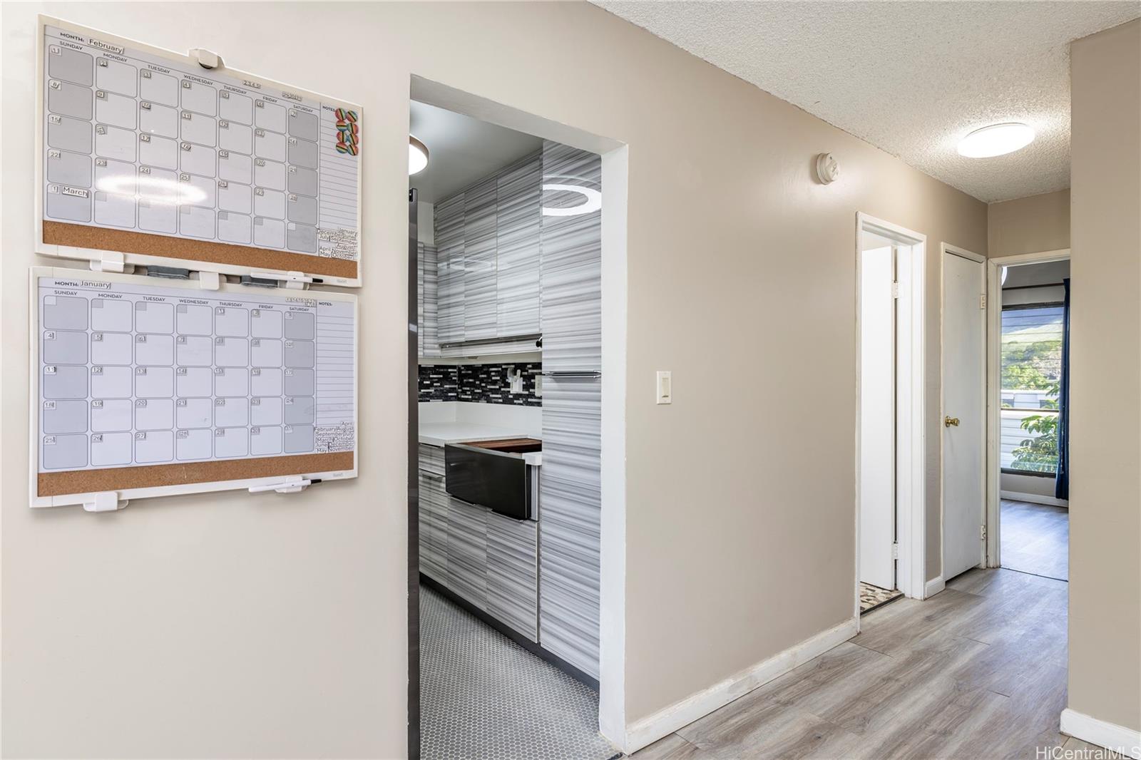 87-131 Helelua Street, Unit J304 Waianae, HI 96792 - Photo 9 of 19 a view of a refrigerator in kitchen and wooden floor