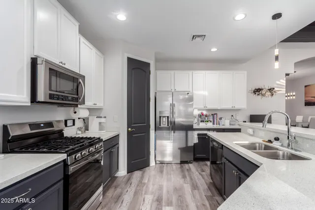a bedroom with a bed a mirror on dresser and a flat screen tv