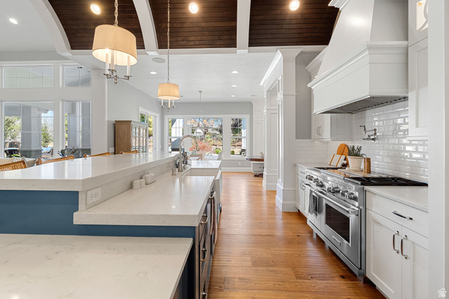 2917 Old Farm Road Washington, UT 84780 - Photo 53 of 105 Kitchen with light stone countertops, range with two ovens, a wood ceiling with exposed beams, light wood finished floors, and white cabinetry