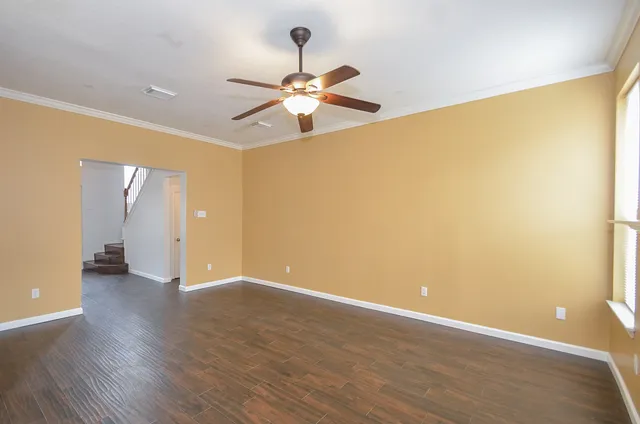 a view of an empty room with wooden floor