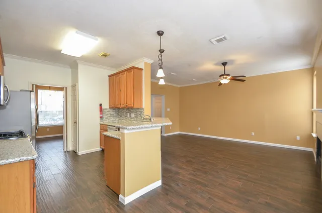 a view of a kitchen with a sink wooden floor and a kitchen space