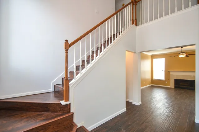 a view of staircase with wooden floor and a rug