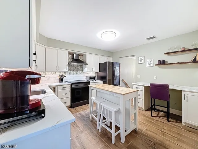 a kitchen with a table chairs a stove a microwave and cabinets