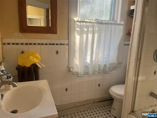 a bedroom with a bed and dresser with mirror