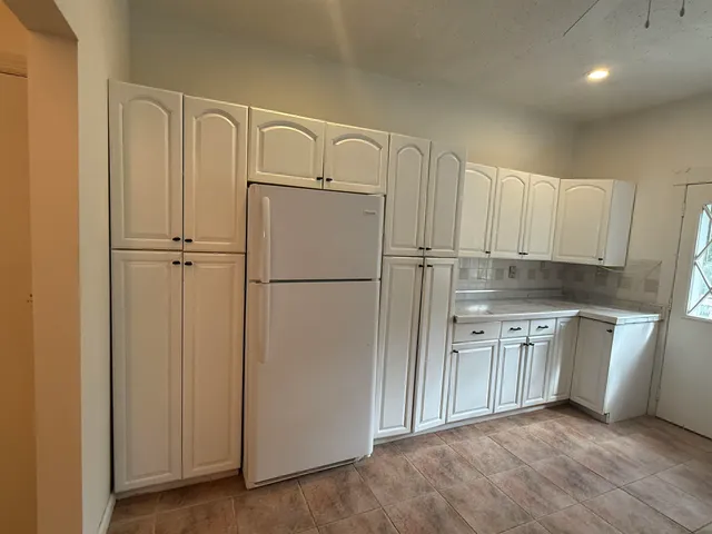 a kitchen with white cabinets and white appliances