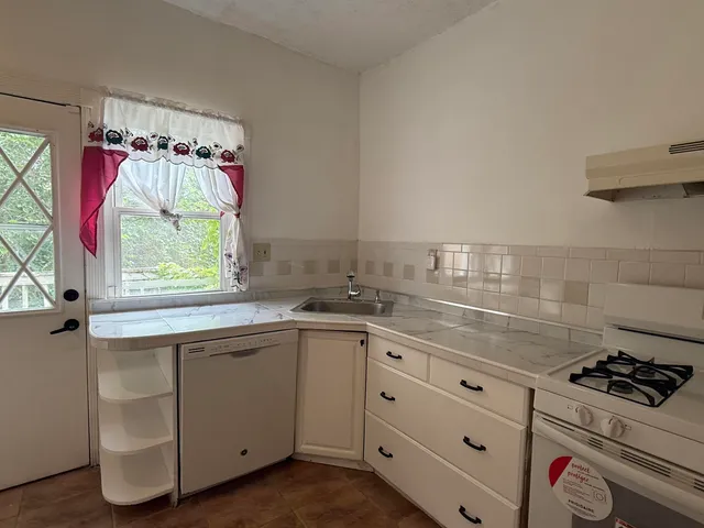 a kitchen with white cabinets appliances and sink