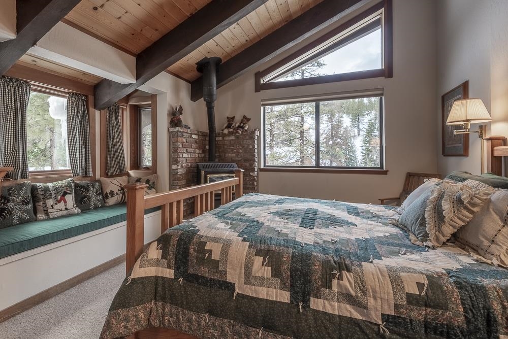 1380 Pine Trail Alpine Meadows, CA 96146 - Photo 15 of 21 a bedroom with a bed a large window and potted plant on the table
