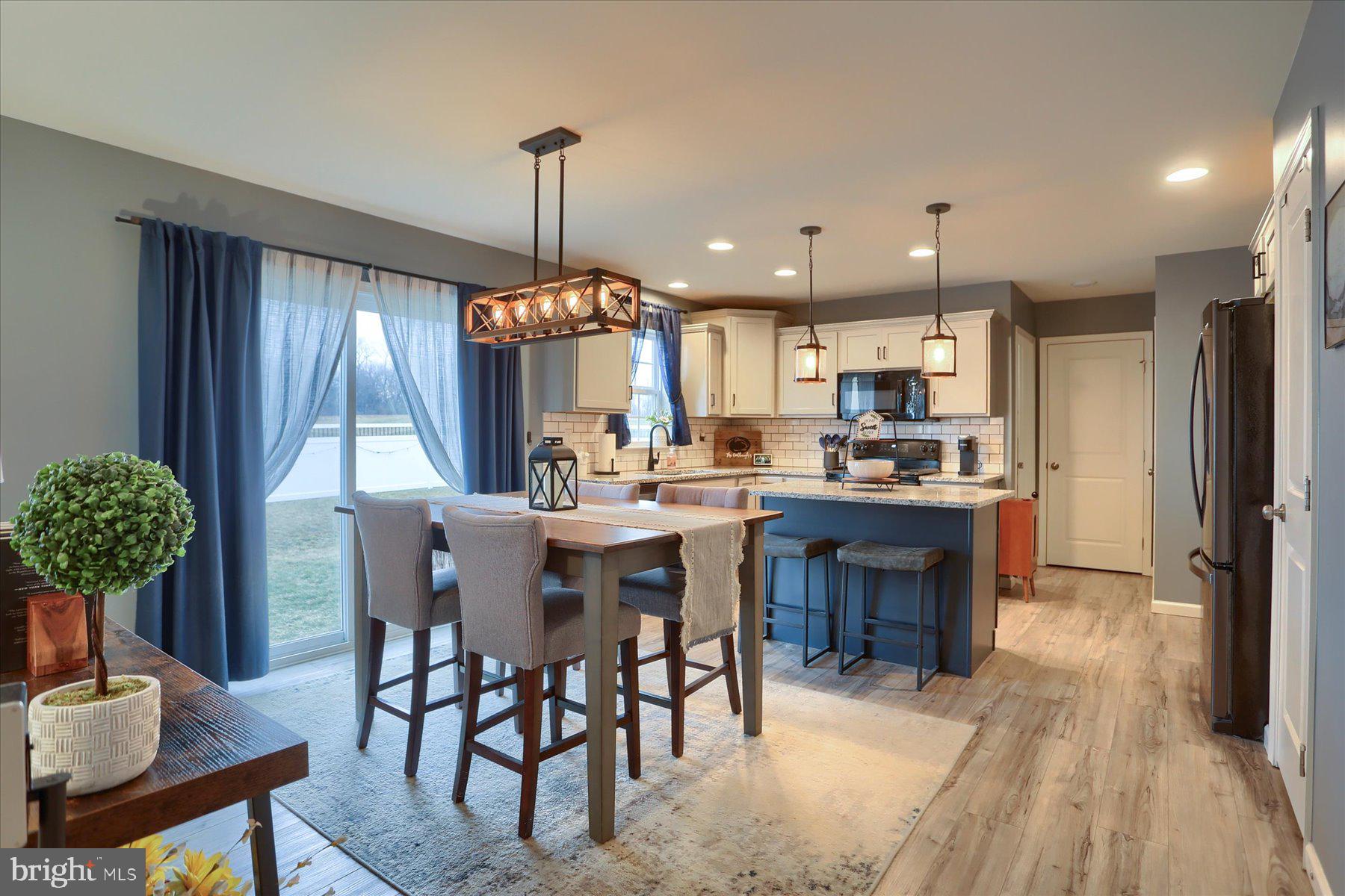 3480 Winter Drive Dover, PA 17315 - Photo 11 of 39 a kitchen with stainless steel appliances granite countertop a refrigerator a oven a sink a dining table and chairs with wooden floor