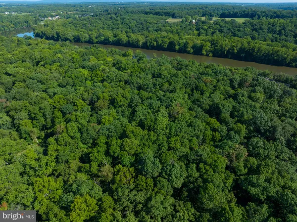 an aerial view of residential house with outdoor space and trees all around