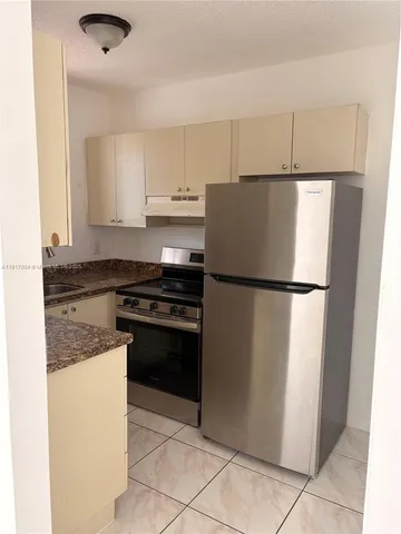 a kitchen with a refrigerator and a stove