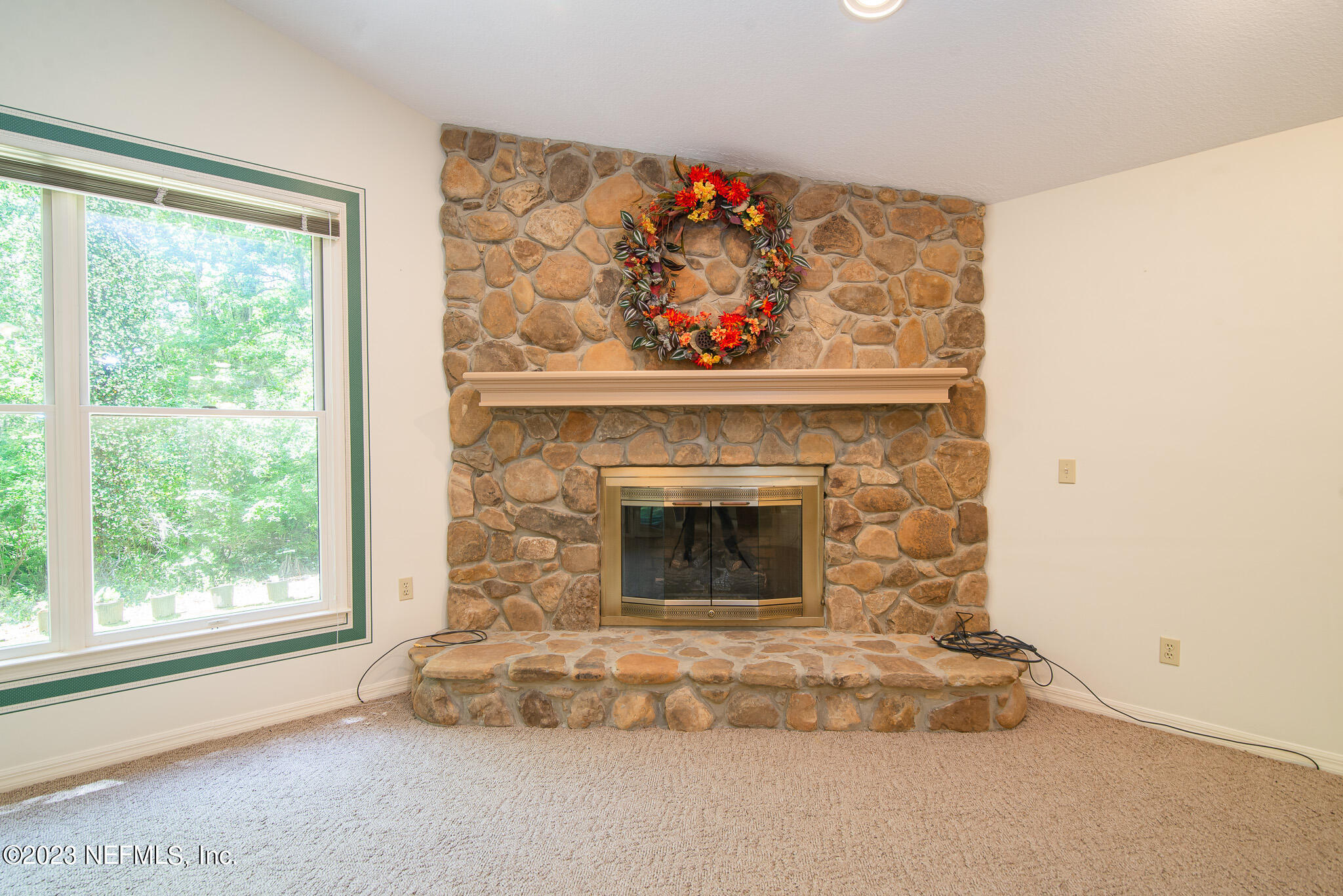 4233 Wicks Branch Road St. Augustine, FL 32086 - Photo 19 of 45 a living room with a fireplace and a large window