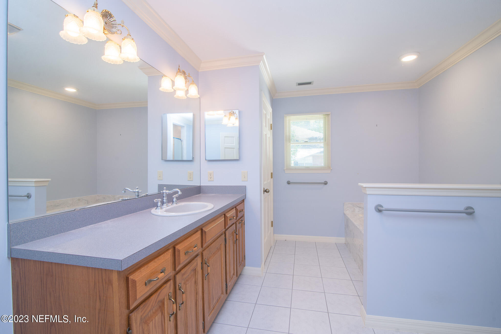 4233 Wicks Branch Road St. Augustine, FL 32086 - Photo 26 of 45 a bathroom with a sink a vanity and a mirror