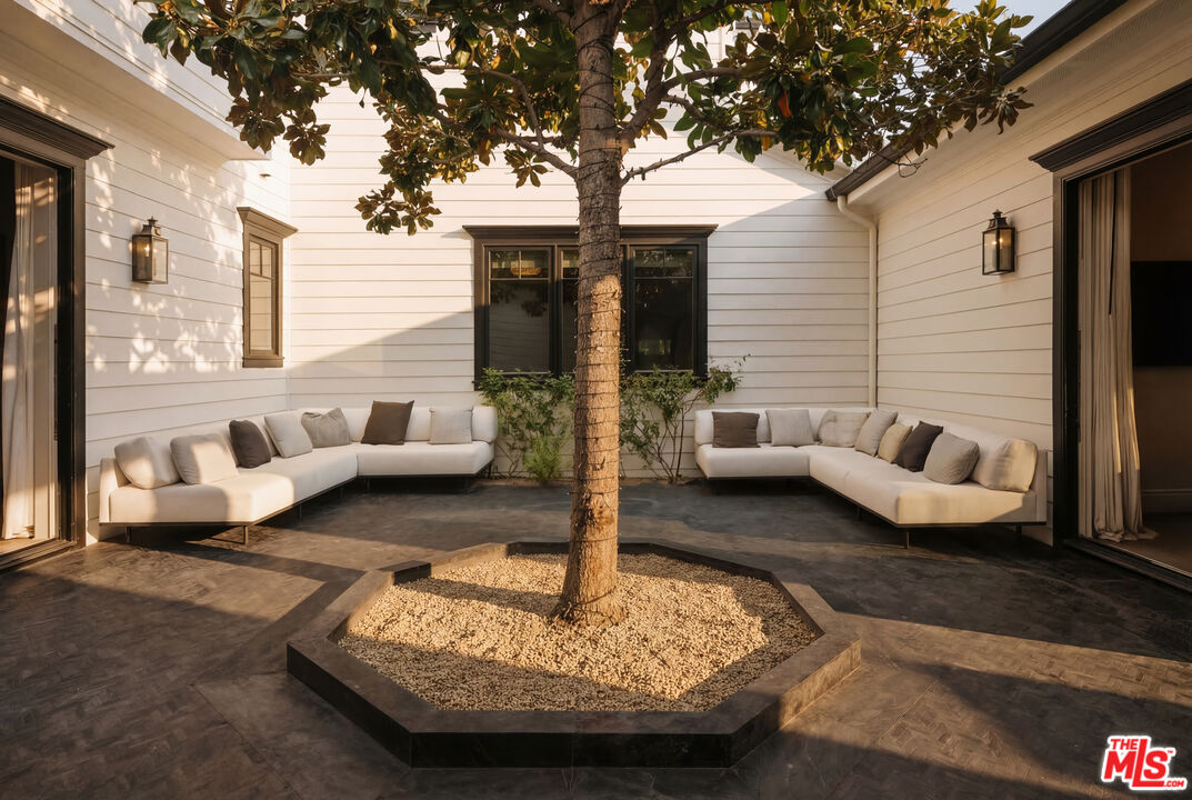 24155 Hidden Ridge Road Hidden Hills, CA 91302 - Photo 20 of 23 a view of a patio with couches chairs and a large tree