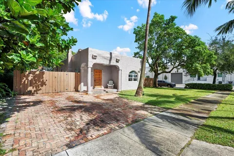 front view of a house with a yard and an trees