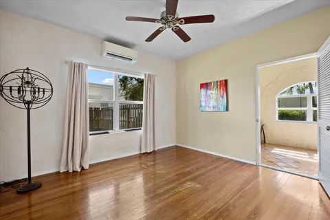 a view of an empty room with a window and wooden floor