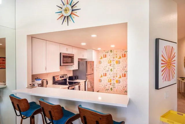 a kitchen with stainless steel appliances kitchen island granite countertop a sink and a stove top oven with granite countertops