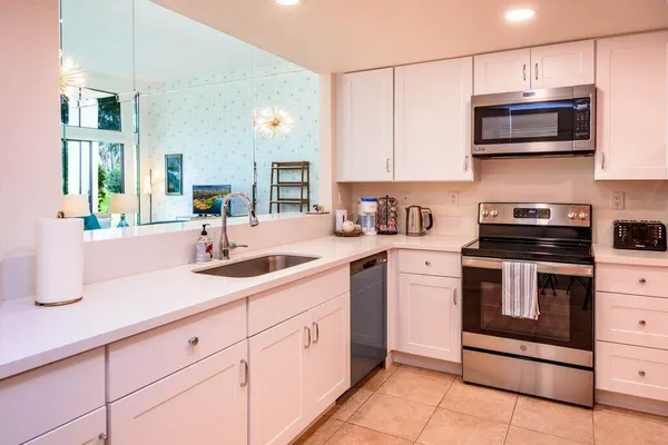 a kitchen with stainless steel appliances granite countertop a sink and a microwave
