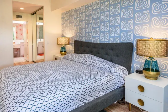 a bedroom with a bed and a painting on the wall