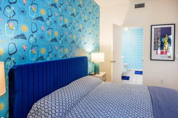 a bedroom with a bed and a lamp on dresser