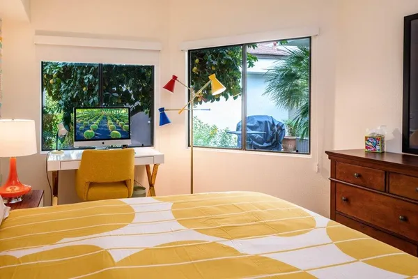 a bedroom with a bed and large windows