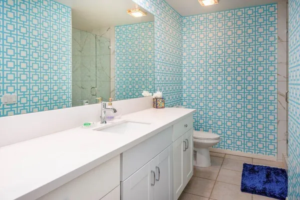 a bathroom with a sink a toilet and a mirror