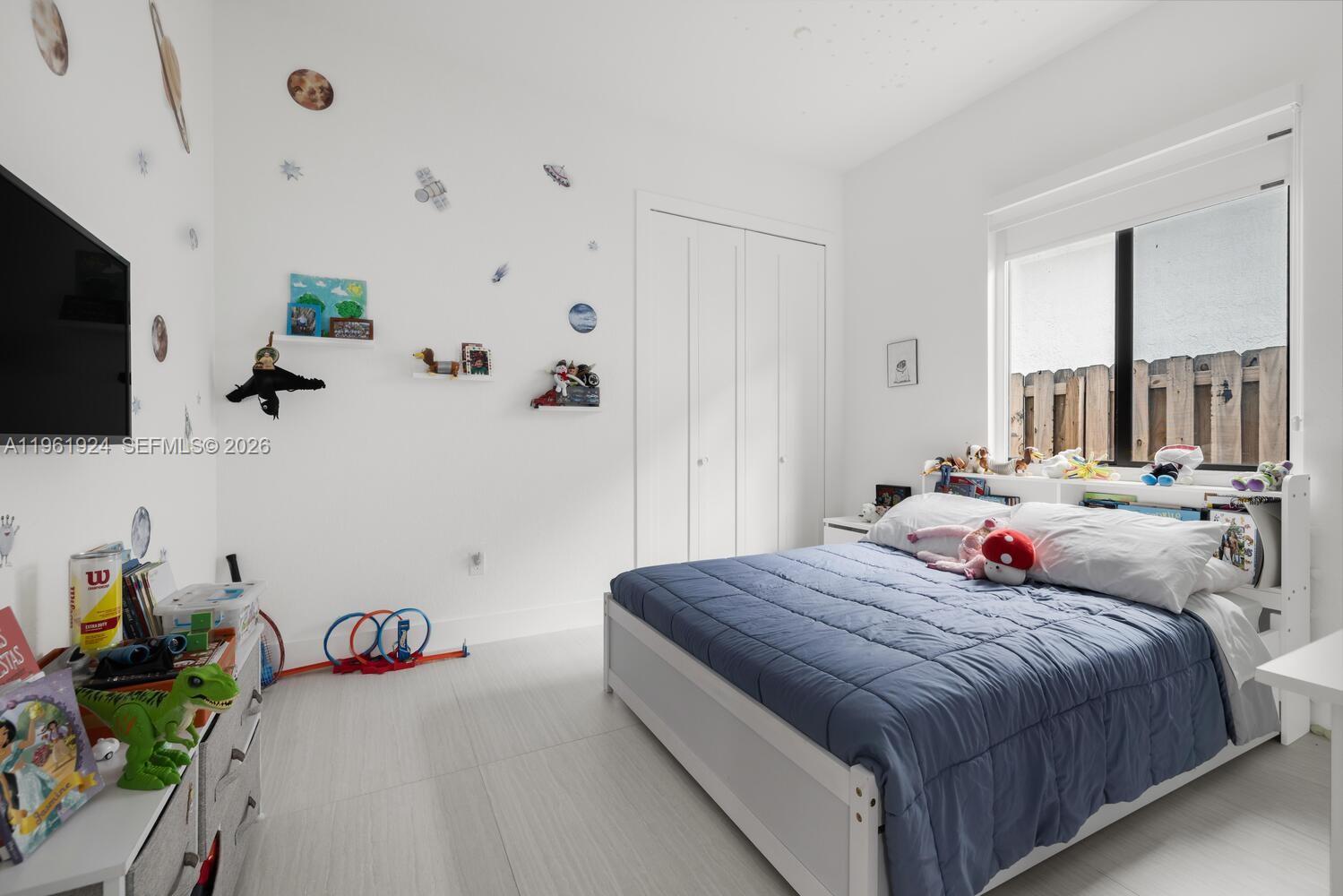 14468 Southwest 16th Street Miami, FL 33175 - Photo 14 of 46 a bedroom with a bed and flat tv screen on the dresser