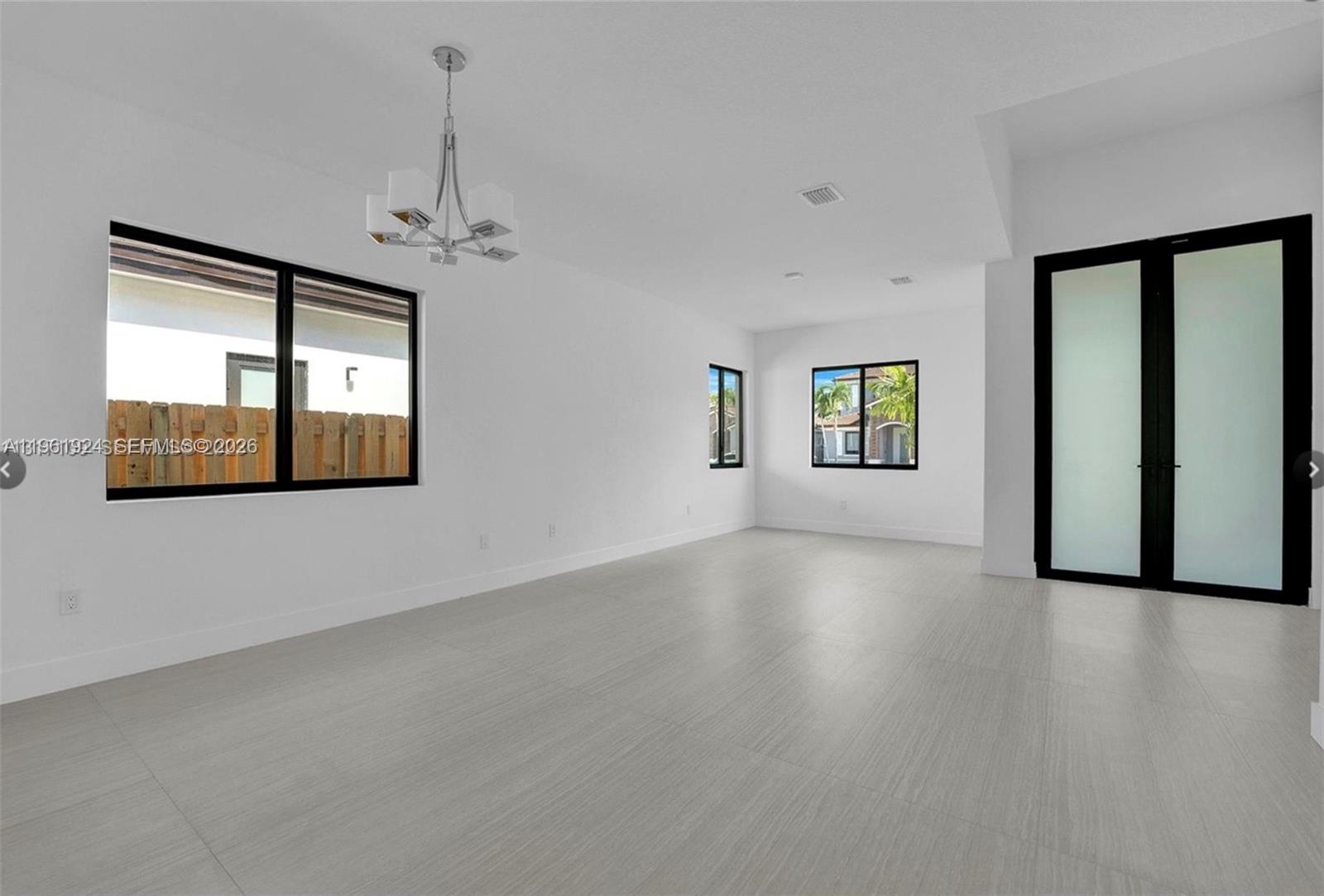 14468 Southwest 16th Street Miami, FL 33175 - Photo 15 of 46 a view of an empty room with a window and wooden floor