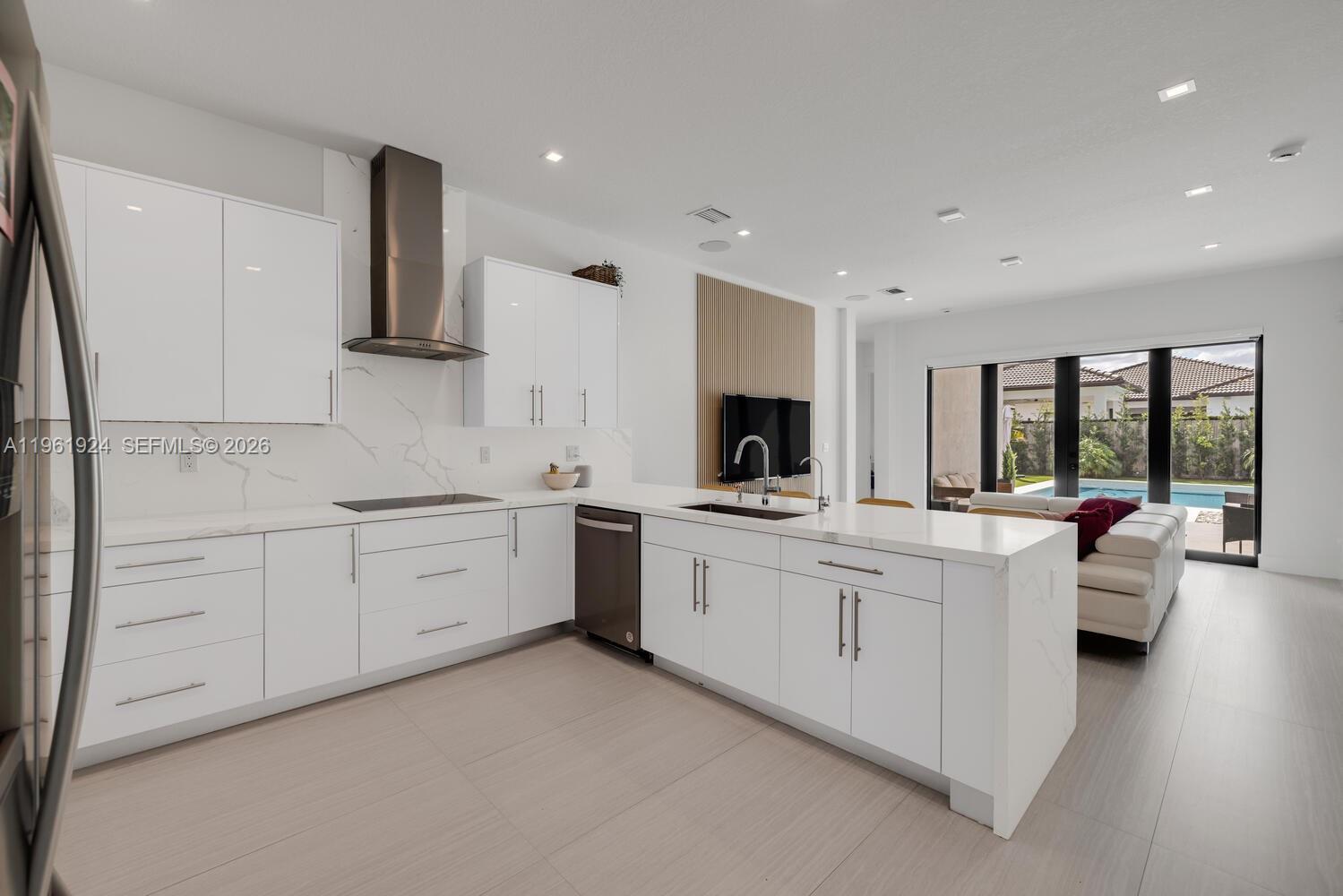 14468 Southwest 16th Street Miami, FL 33175 - Photo 16 of 46 a large white kitchen with a stove a sink dishwasher and a refrigerator with wooden floor