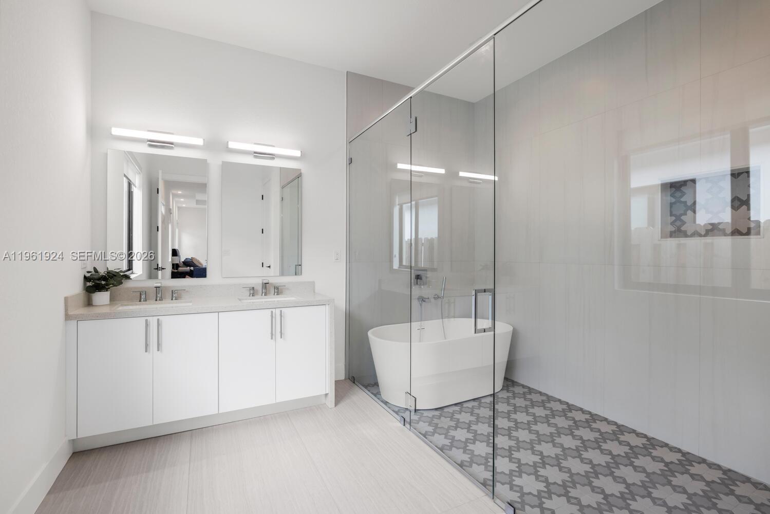 14468 Southwest 16th Street Miami, FL 33175 - Photo 26 of 46 a bathroom with a double vanity sink a mirror and a bathtub