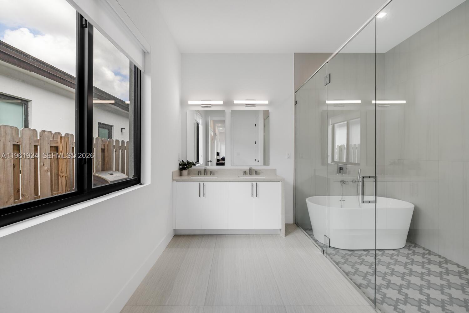 14468 Southwest 16th Street Miami, FL 33175 - Photo 7 of 46 a bathroom with a double vanity sink a mirror and a bathtub