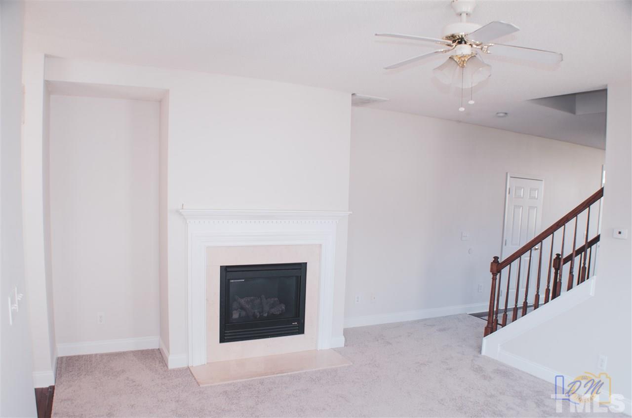 2636 Quarry Ridge Lane Raleigh, NC 27610 - Photo 4 of 12 a view of an empty room with chandelier fan and fire place