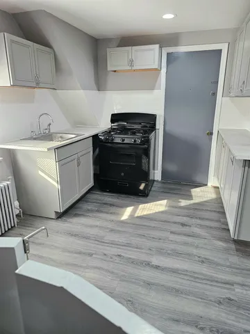 a kitchen with a stove and white cabinets
