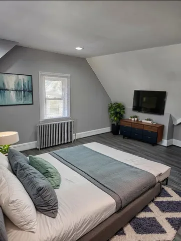 a bedroom with a bed and a flat screen tv