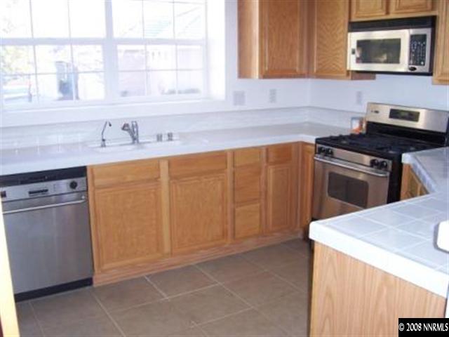 1267 Tule Drive Reno, NV 89521 - Photo 2 of 7 a kitchen with stainless steel appliances granite countertop a sink stove and microwave