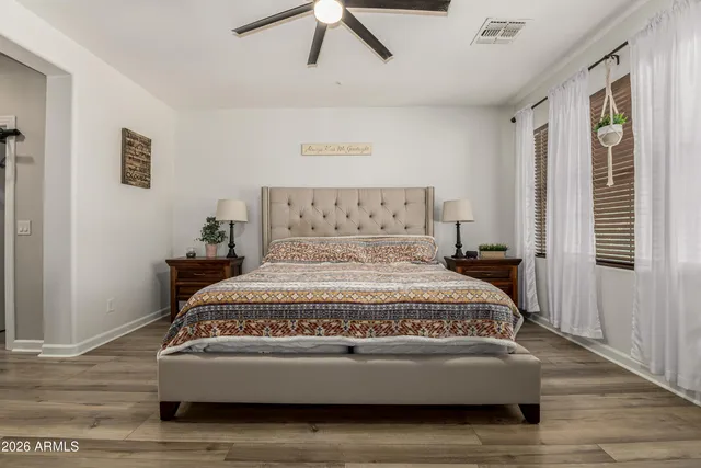 a bedroom with a bed and wooden floor
