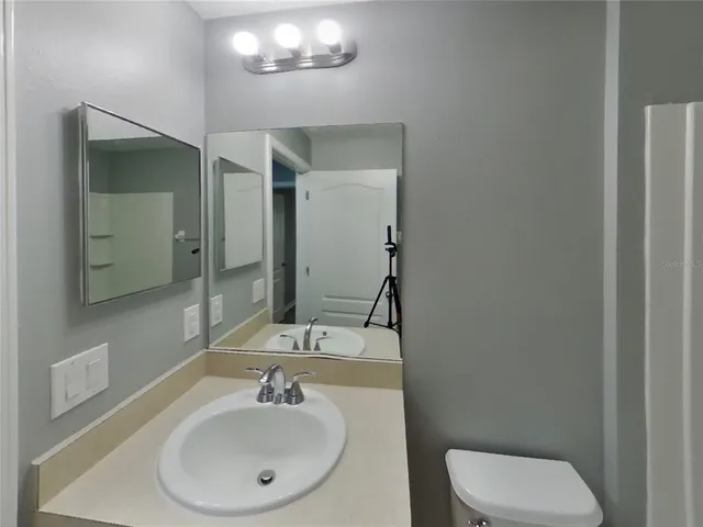 a bathroom with a toilet a sink and mirror