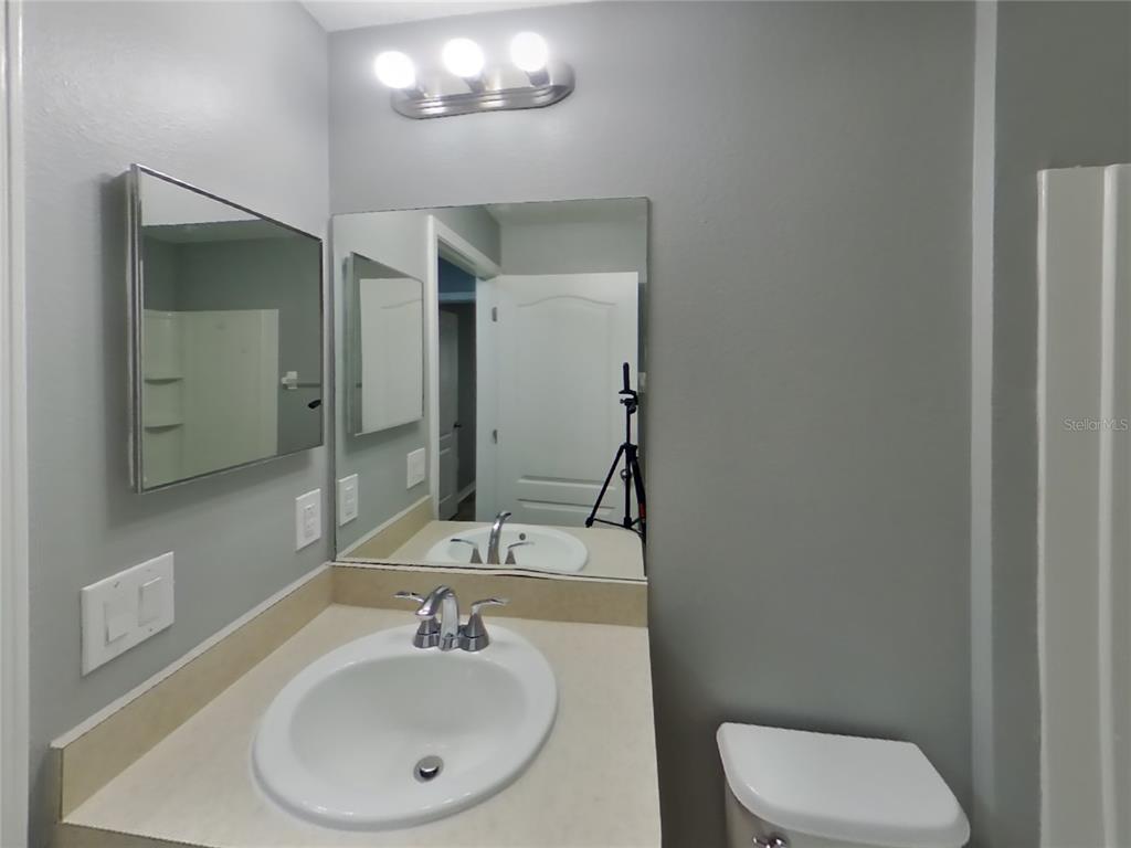 Undisclosed Address Spring Hill, FL 34609 - Photo 13 of 15 a bathroom with a toilet a sink and mirror