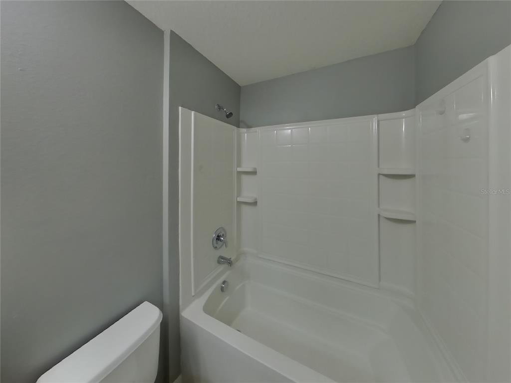 Undisclosed Address Spring Hill, FL 34609 - Photo 14 of 15 a bathroom with a bathtub and shower