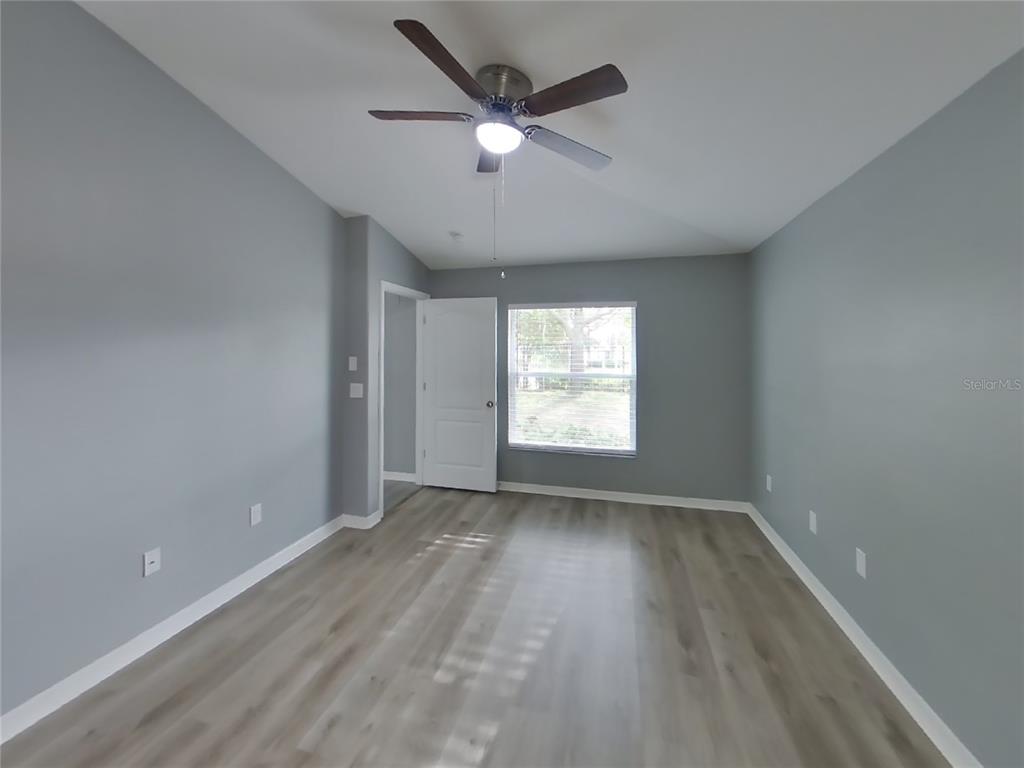 Undisclosed Address Spring Hill, FL 34609 - Photo 7 of 15 an empty room with wooden floor and windows
