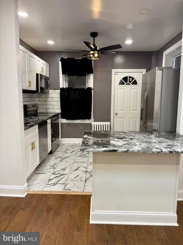 a large kitchen with kitchen island a sink stainless steel appliances and cabinets