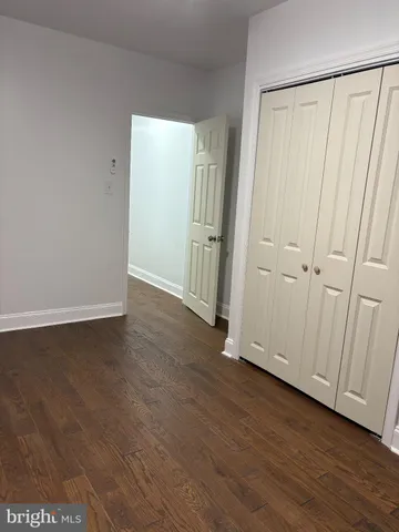 an empty room with wooden floor and a window