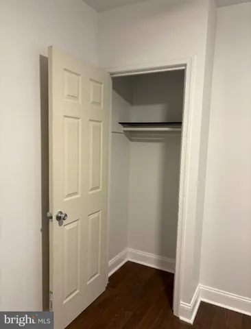 an empty room with wooden floor and closet