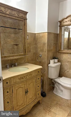 a bathroom with a granite countertop toilet sink and mirror