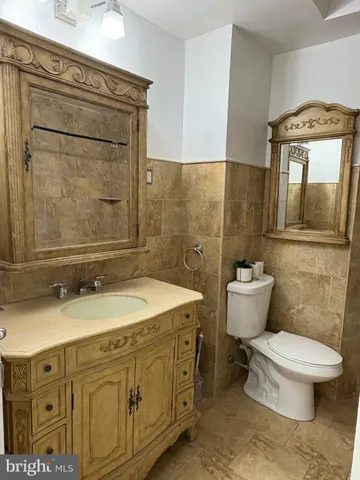 a bathroom with a granite countertop toilet a sink and mirror