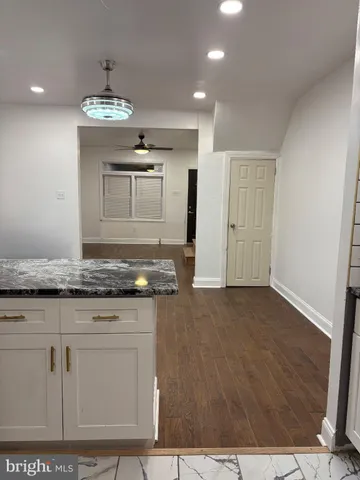 a kitchen with granite countertop a stove and white cabinets