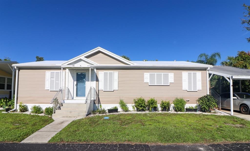 24437 Harbor View Road, Unit 101 Port Charlotte, FL 33980 - Photo 1 of 1 a front view of a house with a yard
