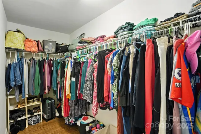 a view of walk in closet with clothes