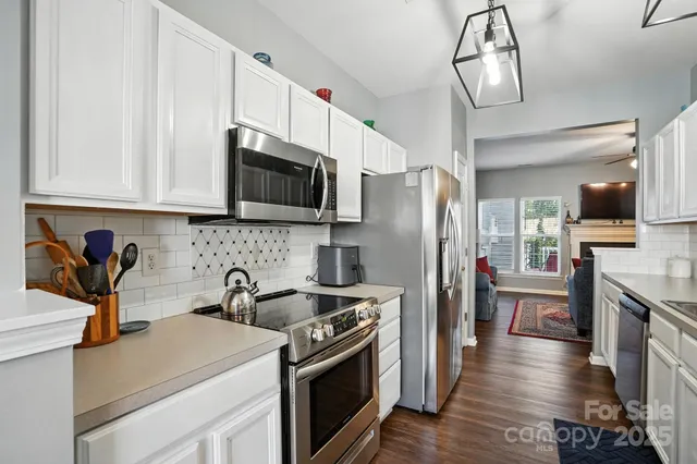 a kitchen with stainless steel appliances granite countertop a refrigerator stove microwave and sink