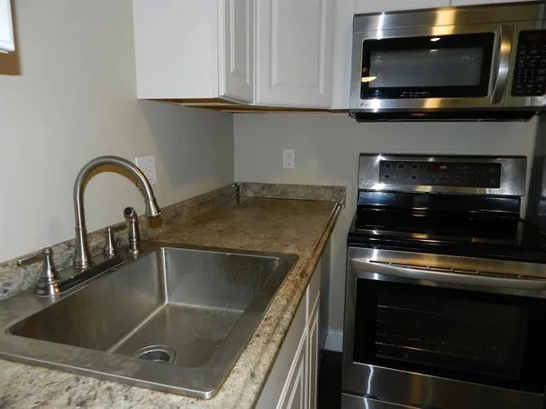 a kitchen with granite countertop a stove and a sink