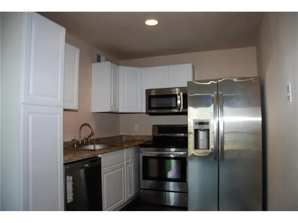 a kitchen with appliances a sink and cabinets